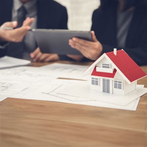 Lawyers analyze estate planning with a house model - Maines Legal